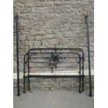 A Victorian cast iron 4ft 6 double bedstead with tubular arched rails, enclosing decorative shaped