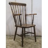 A Windsor stained elm and beechwood stick back open elbow chair with saddle shaped seat raised on