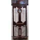 A late Victorian mahogany hall stand of full height incorporating a circular mirror plate over a