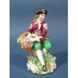 A Sitzendorf figure of a seated gentleman with a basket of flowers and floral encrusted decoration