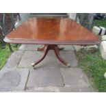 A Georgian mahogany breakfast table with rectangular top, raised on a turned pillar and reeded