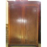 An Edwardian mahogany hanging wardrobe in a Georgian style enclosed by two panelled doors, 130cm