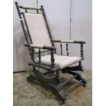 A late 19th/early 20th century American rocking chair with simple upholstered pad seat and back