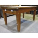 A 19th century stripped pine farmhouse kitchen table with rectangular top over an end frieze