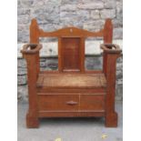 A 1920s oak hall bench and combined umbrella stand, with hinged box seat, shaped outline and applied