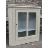 A 19th century countrymade hanging corner cupboard enclosed by a twin rectangular glazed panelled