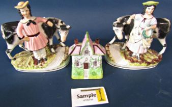Two 19th century Staffordshire figures of a farmer and his wife, each with a cow beside a stream,