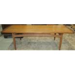 A mid-20th century long and low teak occasional table of rectangular form with cleated and