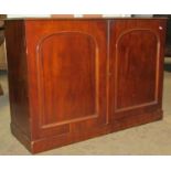 A Victorian mahogany side cupboard enclosed by a pair of arched and panelled doors, 110cm wide x