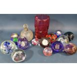 Twelve Caithness paperweights of varying shapes and sizes, a red glass vase and a cut glass scent