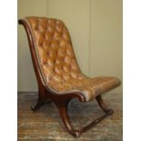 A Regency style mahogany framed drawing room chair with swept outline, upholstered in buttoned brown