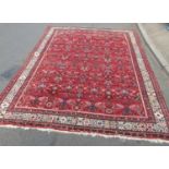A large Sarouk design carpet with an all over floral pattern on a red ground, 310cm x 210cm approx