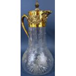 An Asprey silver gilt bacchanalian decorated claret jug with engraved grape and vine glass, 33cm