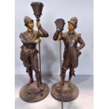 A pair of painted spelter figures of soldiers holding braziers. (As found)