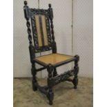 A single antique oak chair in the Carolean style with cane panelled seat and back beneath a carved