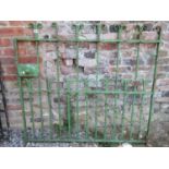 A 19th century wrought iron pedestrian side gate with simple square vertical bars with scroll