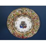 A Capodimonte armorial plate with elaborate decoration to the rim in low relief depicting dancing