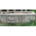 A weathered cast composition stone flower trough of rectangular form with repeating harvesting