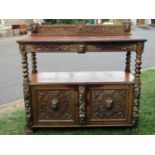 A Victorian carved oak buffet with lions mask, trailing fruit, vine, geometric and further detail,