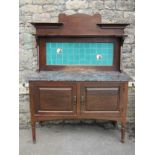 An arts and crafts walnut washstand with marble top and tiled splash back, the base enclosed by