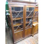 A Georgian mahogany bookcase enclosed by a pair of panelled doors with partial astragal glazing,