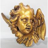An Angel’s face, terracotta with a gold finish.