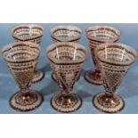 Six red engraved conical shaped liqueur glasses.