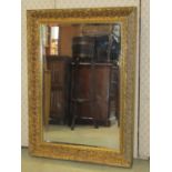 A contemporary antique style wall mirror of rectangular form with bevelled edge plate within a