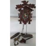A simple Tyrolean cuckoo clock in the form of a chalet, surmounted by a bird and vine leaves with