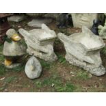 A pair of novel cast composition stone garden planters in the form of vintage wheelbarrows, together
