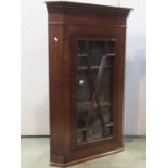 A Georgian style mahogany hanging corner cabinet enclosed by an astragal glazed panelled door,