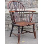 A Georgian hoop back elbow chair in mixed woods including elm, yew, etc with pierced splat