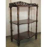 A Victorian rosewood three tier what-not, with serpentine fronted shelves, raised on turned supports