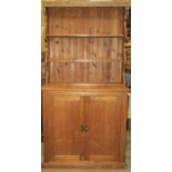 A reclaimed stripped pine cottage dresser, the base enclosed by a pair of rectangular panelled doors