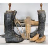 A pair of vintage black riding boots with wooden trees and an assortment of other boot trees, (as