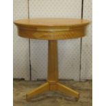 A contemporary reproduction maple veneered occasional table of circular form, raised on a tapered