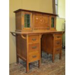An arts and crafts oak writing desk - Stone's Patent, the lower section fitted with six drawers