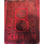 A small Turkoman rug with two elephant foot on a red ground 120cm x 80cm approx.