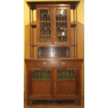 An arts and crafts oak dresser, the lower section enclosed by a pair of panelled doors, partially