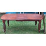 A late Victorian walnut wind-out extending dining table with rounded moulded edge, single additional