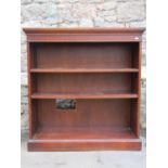 A reproduction mahogany floorstanding open bookcase with two adjustable shelves, 97cm wide x 32cm