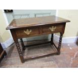 An antique oak side table enclosing two frieze drawers, raised on turned bobbin supports, 78cm wide