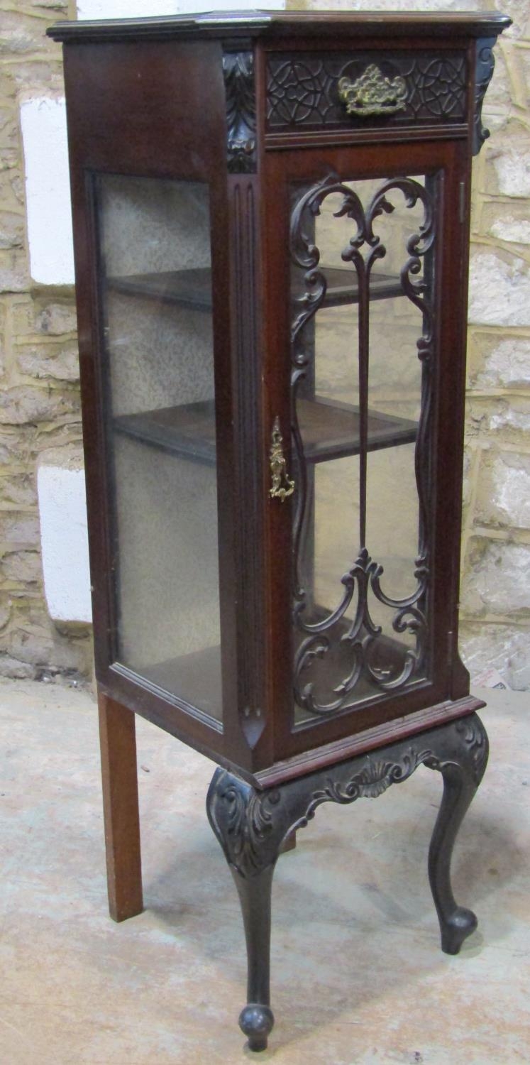 A slender Edwardian mahogany side cabinet enclosed by a rectangular glazed panelled door with