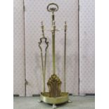 A good quality polished brass fireside companion set and stand, the central column set on a D shaped