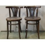 A pair of vintage bentwood café chairs with circular seats, comb splats and curved bar backs