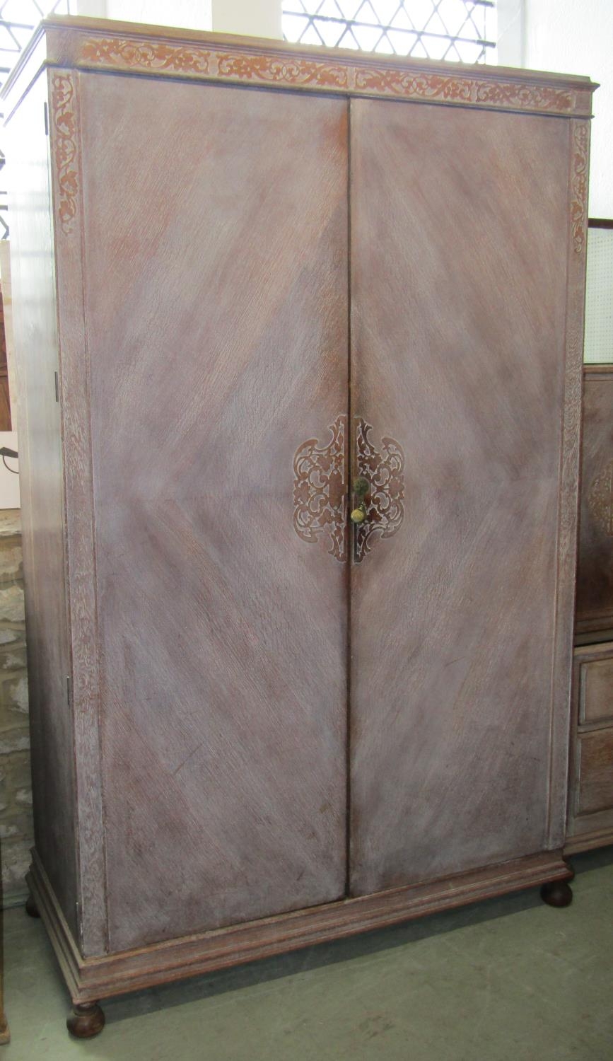 An early 20th century limed/fumed oak bedroom suite comprising two sectional wardrobe enclosed by