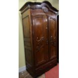 18th century cherrywood armoire enclosed by a pair of shaped and panelled doors over a single frieze