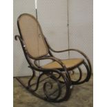 A vintage Bentwood rocking chair with cane panelled seat and back stamped Thonet, Austria