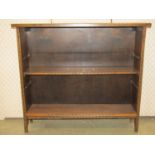An arts and crafts style dwarf oak freestanding open bookcase with repeating chip carved detail