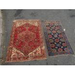 An antique worn and torn Persian rug with a floral pattern 175cm x 95cm and another old Middle